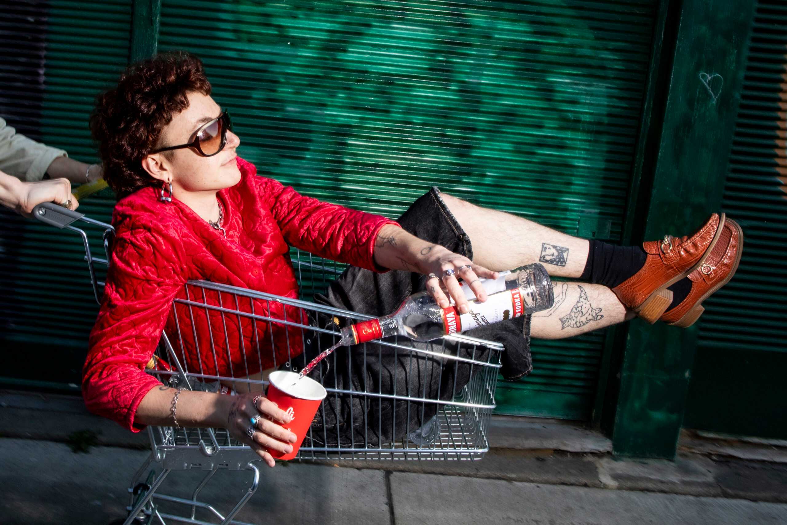 Person in Shopping cart filling Stolichnaya into cup